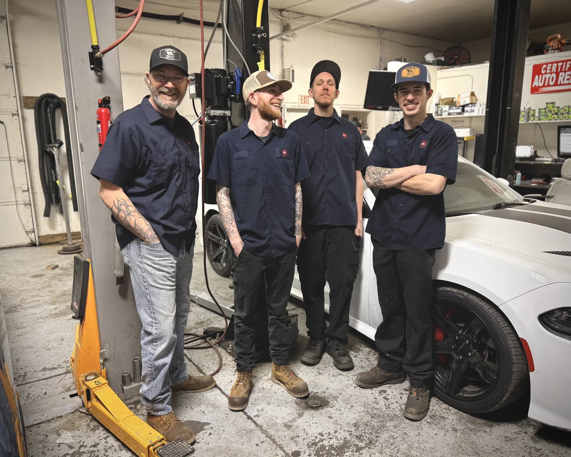 auto repair technicians working on vehicle in shop