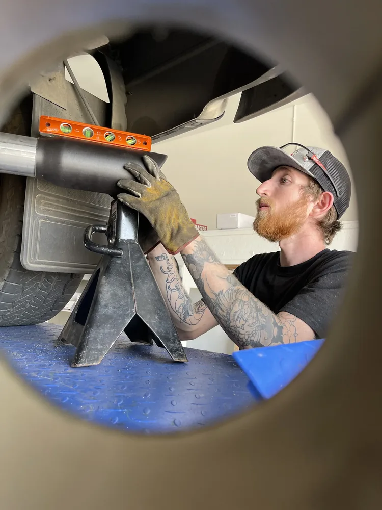 custom exhaust tip installation and alignment on truck lift