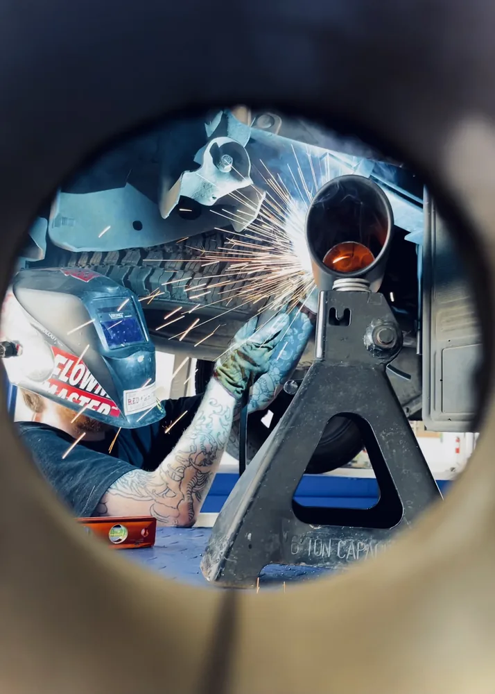 custom exhaust welding sparks under vehicle on lift