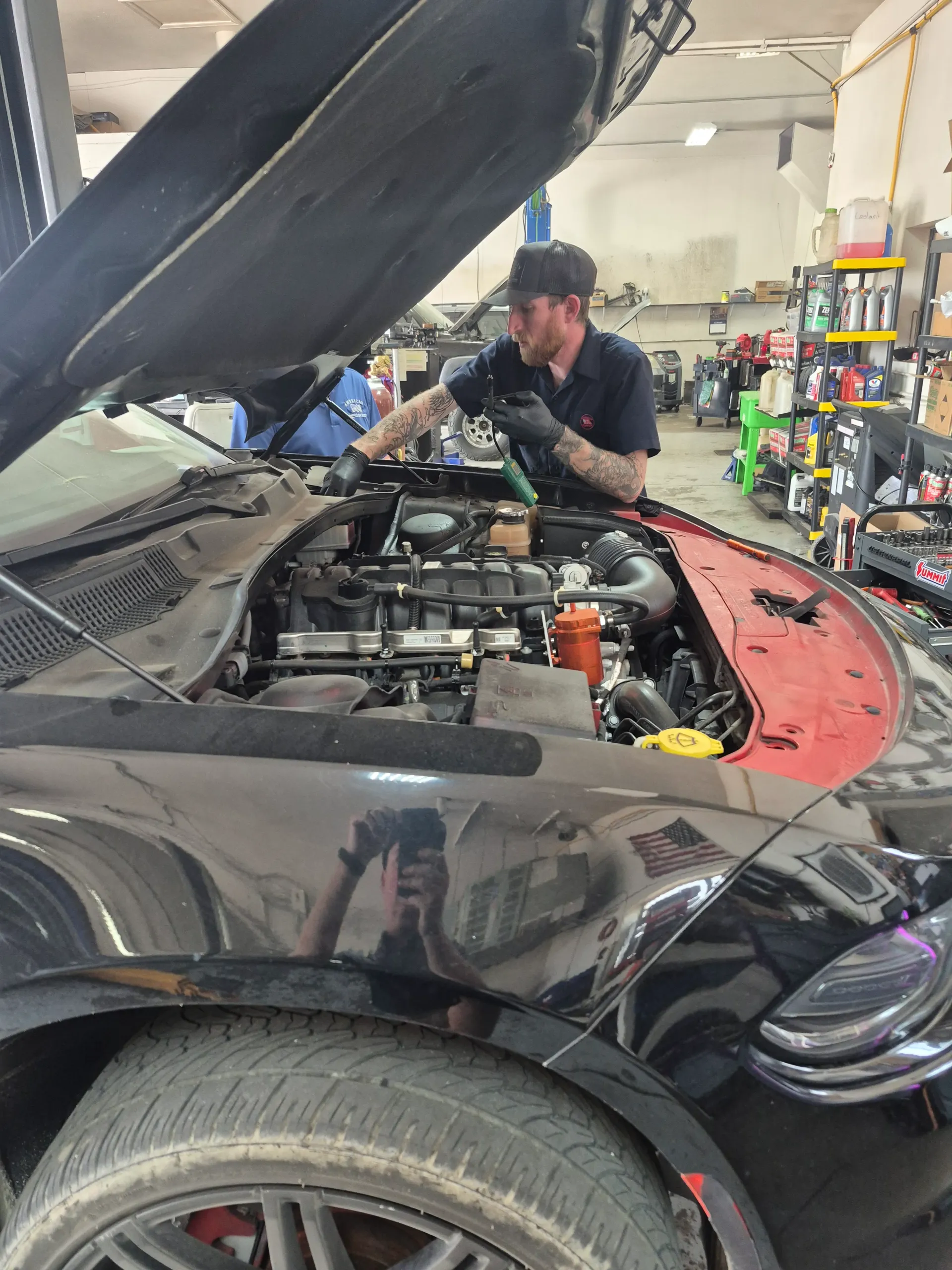 engine bay inspection with diagnostic equipment nearby