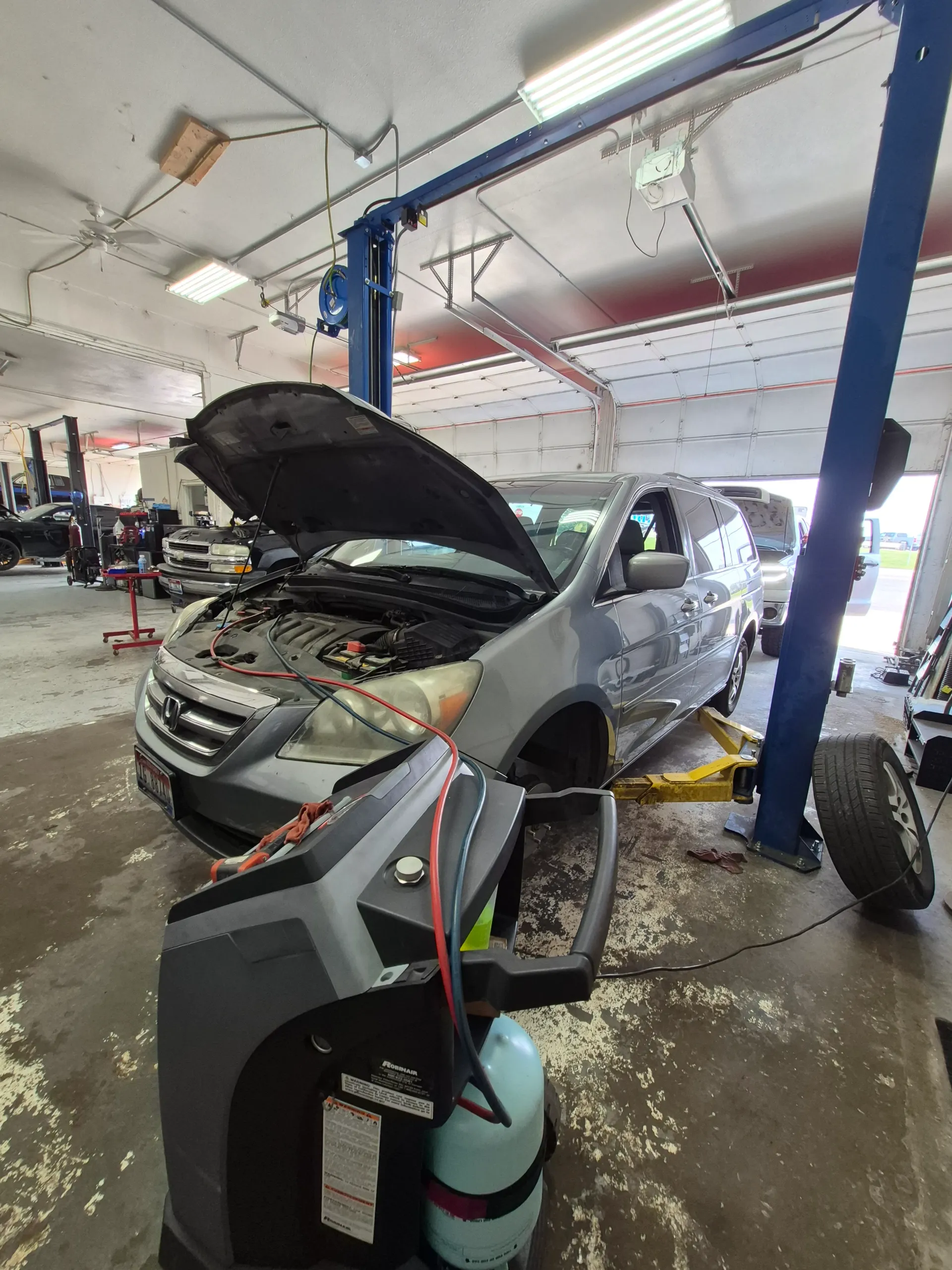 minivan air conditioning recharge beside repair lift